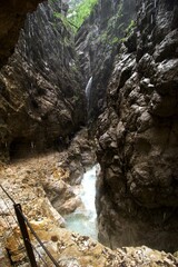 deep gorge with rocks and turquoise white water creek passing