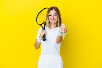 Young Romanian woman isolated on yellow background playing tennis and doing coming gesture