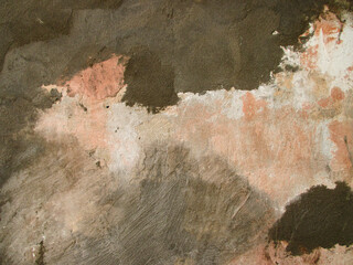 The background of an old wall with noble whitewash is roughly covered with cement. Once this color was called peach or beige. The wall is being prepared for restoration. 