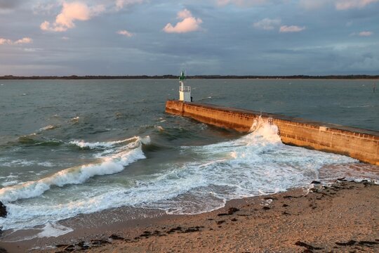 Waves splashing on the pier at sunset 