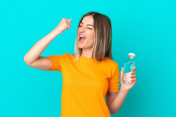 Young Romanian woman with a bottle of water isolated on blue background celebrating a victory