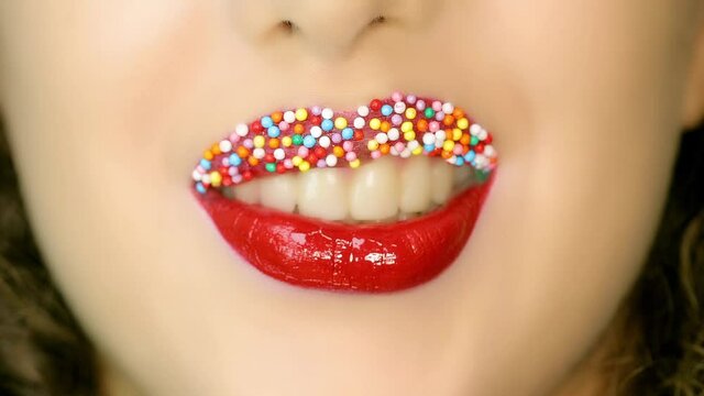 Closeup of a beautiful woman lips with beautiful colorful make up sending air kiss . Close up of girl's mouth having flirty emotions and sending air kiss .