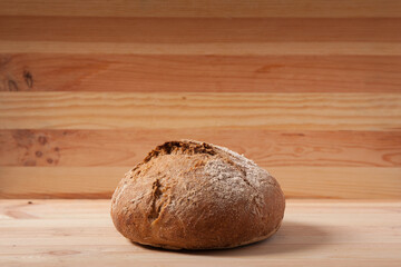 Handmade fresh wheat bread on wooden background in the morning light. horizontal frame side view with space area for text or design