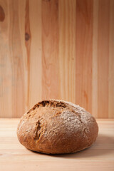 Handmade fresh wheat bread on wooden background in the morning light. vertical frame side view with space area for text or design