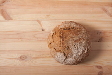 Handmade fresh wheat bread on wooden background in the morning light. horizontal frame top view with space area for text or design