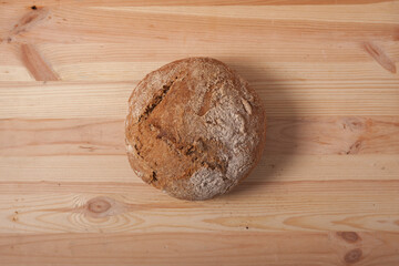 Handmade fresh wheat bread on wooden background in the morning light. horizontal frame top view with space area for text or design