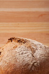 Handmade fresh wheat bread on wooden background in the morning light. vertical close-up frame side view with space area for text or design.