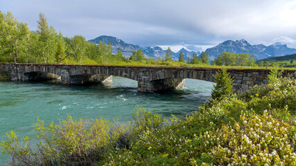 Fototapeta na wymiar Saint Mary River Bridge - A wide-angle view of Saint Mary River Bridge on a Spring evening in Glacier National Park. Montana, USA. 