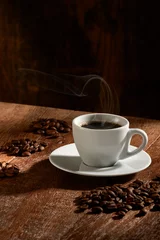 Fotobehang Koffie Kopje koffie geïsoleerd op rustieke houten achtergrond, verticaal met groepen geselecteerde koffiebonen rond.