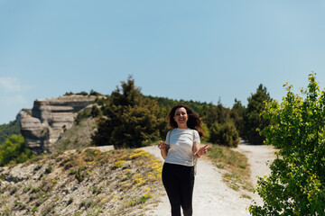 a beautiful woman walking along a mountain road on a hiking trip