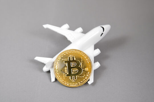 Blockchain airline ticket concept. Bitcoin Gold coin, plane on grey background. electronic virtual money. - Powered by Adobe