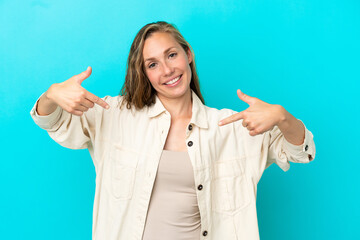 Young caucasian woman isolated on blue background proud and self-satisfied