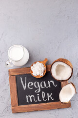 Fototapeta na wymiar Chalk board and vegan powdered coconut milk, lactose free milk, vertical, top view, copy space