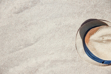 Stylish beautiful hat on the sand shore of the sea background