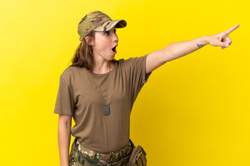 Fototapeta na wymiar Military caucasian woman with dog tag isolated on yellow background pointing away