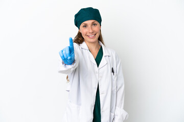 Surgeon caucasian woman in green uniform isolated on white background showing and lifting a finger