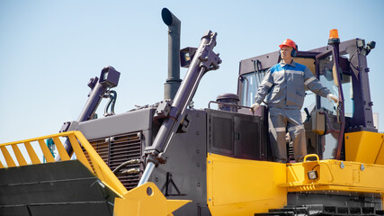 Portrait of industry mechanical worker on bulldozer on open pit mine © Parilov