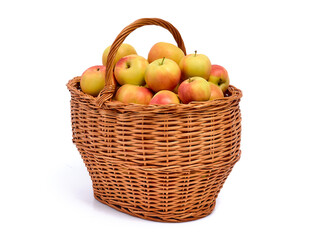 Fresh ripe yellow with red apples in a wicker basket, isolated on a white background
