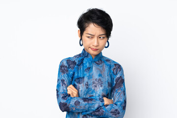 Young Vietnamese woman with short hair wearing a traditional dress over isolated white background with unhappy expression