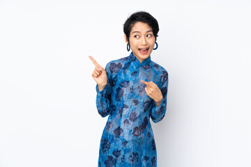 Young Vietnamese woman with short hair wearing a traditional dress over isolated white background intending to realizes the solution while lifting a finger up