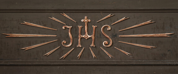 Very nice old IHS sign (Christogram) carved from wood on a wooden background - Powered by Adobe