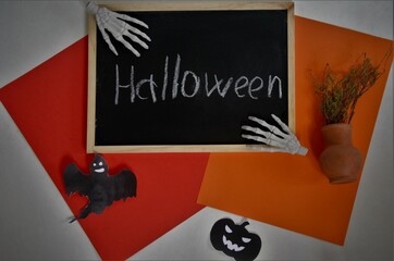 Halloween board with the inscription holds skeletal brushes, on a colored background red and orange