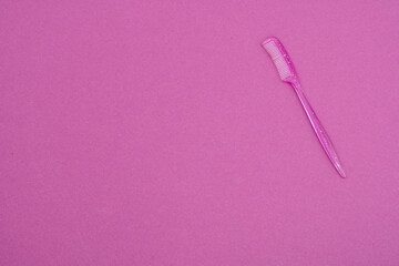 eyebrow brush on pink background