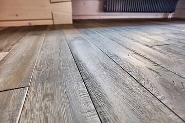 Close-up of natural wood parquet floor room with wooden walls in country house