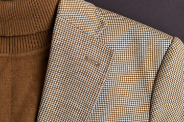 Detail of fashionable mens brown sweater combined with light beige blazer on. 