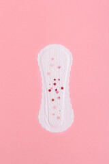 White sanitary pad with pink sparkling glitter on it, woman health concept.  Sanitary pad on pink background.