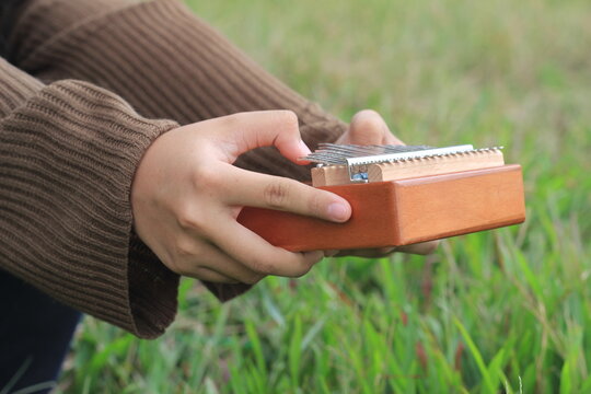 Photo Girl Playing Kalimba, acoustic music instrument from africa 
