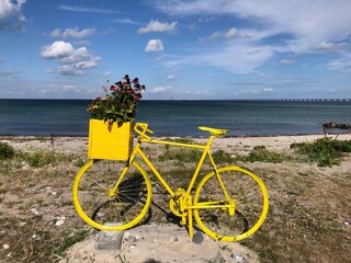 Fototapeta premium Old, decorative, yellow bike by the coast