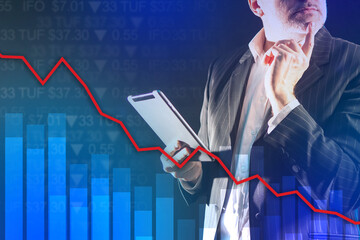 Financial analysis. A man analyzes stock market data. Falling stock indexes. Decline in securities quotations. Market is located in the red zone. Businessman on the background of a declining schedule.