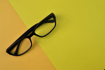 Eyeglasses on yellow and orange background. Copy space