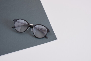 trendy eye glasses on a gray background, geometry background copy space, top view