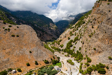 Aerial view of towering, cloud covered mountains at the exit of the Samaria Gorge (Agia Roumeli,...