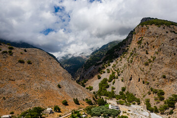 Aerial view of towering, cloud covered mountains at the exit of the Samaria Gorge (Agia Roumeli,...