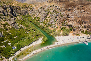 Aerial view of a palm forest and river leading to a clear blue ocean (Preveli, Crete, Greece)