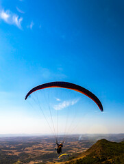 two paraglides flying over mountains in Po&ccedil;os de Calda Brazil.