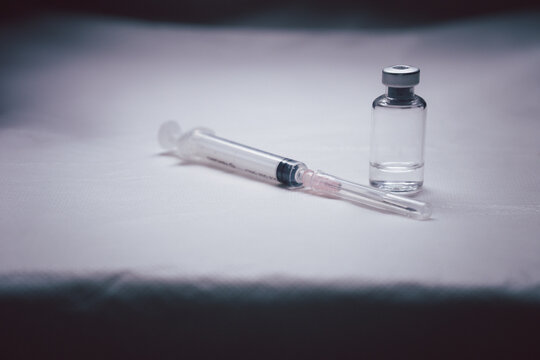 Medicine vial and botox hyaluronic collagen or flu syringe. a syringe with a vial of medication closeup, medicine background