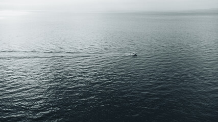 lone captain in the middle of the ocean - aerial drone view