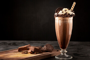 Chocolate milkshake with pieces of chocolate chip cookies.