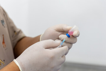 doctor with white gloves preparing vaccine