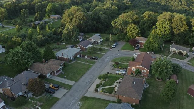 A slow forward tilt up evening aerial establishing shot of a typical rust belt Pennsylvania neighborhood. Pittsburgh suburbs.  	