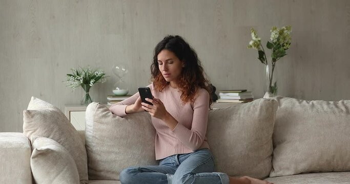 Overjoyed emotional young hispanic woman getting message with amazing news on cellphone, celebrating online lottery gambling giveaway win, feeling festive excited, internet fortune success concept.