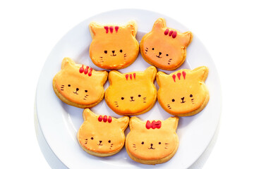 orange cat royal icing cookies on white plate