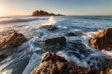 rocks and water with an island in the morning sun