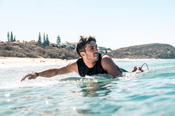 Close up of active Surfer Paddling to Catch a Wave in Sunshine Beach, Queensland.Lifestyle concept