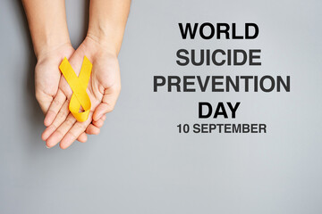 World Suicide prevention Day, hand holding Yellow Ribbon for supporting people living and illness - Powered by Adobe