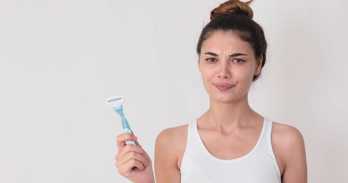 Image of pleased woman frowning while holding razor isolated over white background